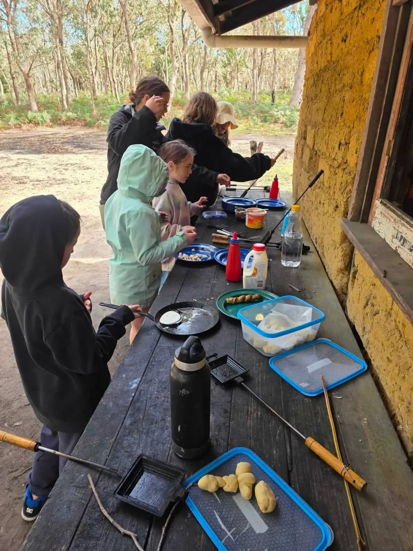 Students preparing food at an outdoor camp kitchen