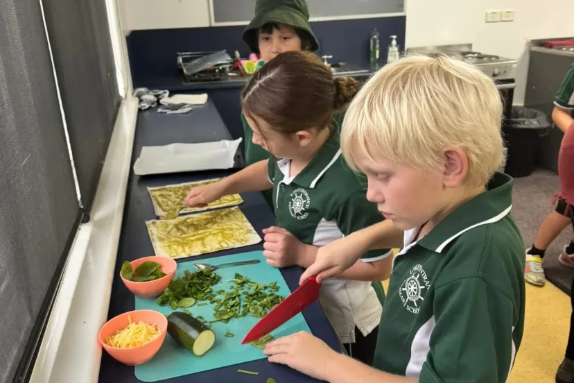 Students chopping vegetables in a cooking lesson