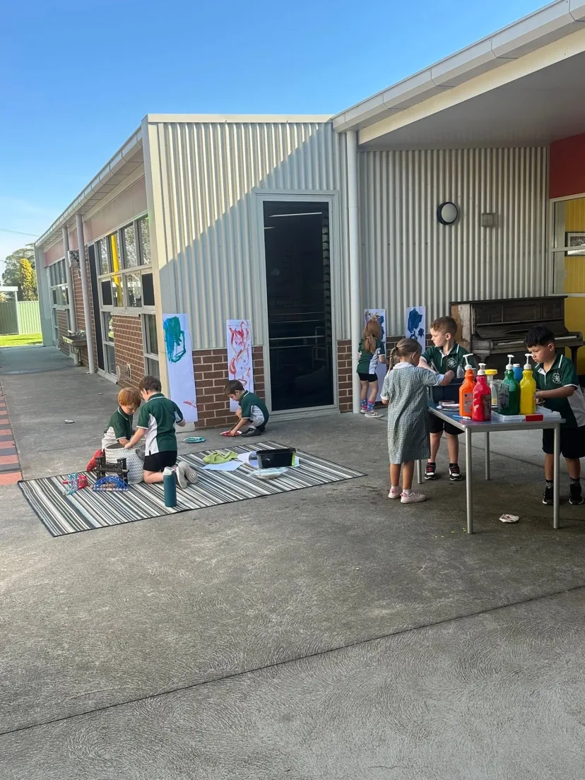 Students working outside the school buildings on a clear day
