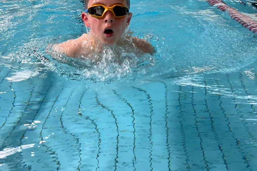 A student swimming towards the camera in the pool