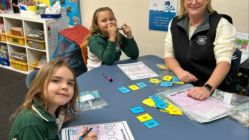 A teacher working with a small group of students at a round table