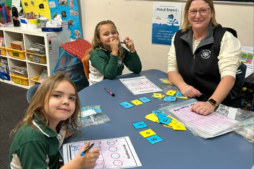 A teacher working with a small group of students at a round table