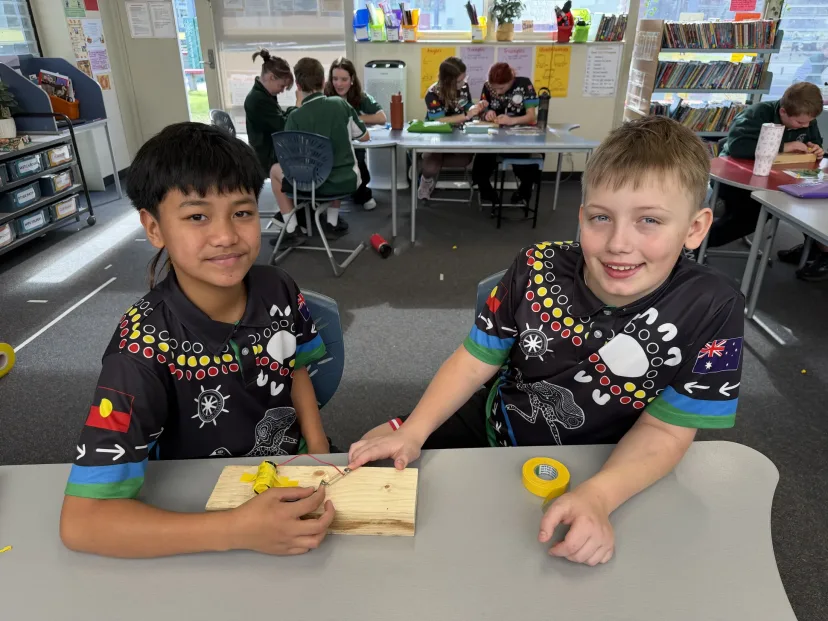 Two students showing the timber project they are working on